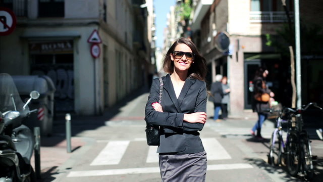 Businesswoman walking on street and smiling.