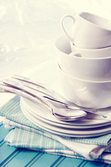 White plates and cups on blue napkins