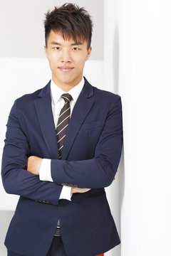 Confident Businessman Cross Arms With Wall