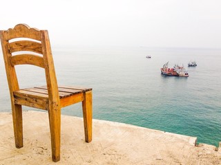 A wooden chair at panorama sea view point