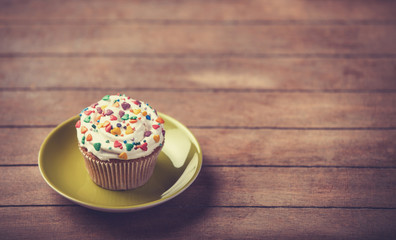 Cream cake with plate on a wooden table.
