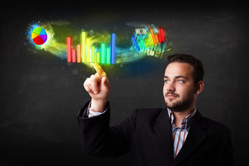 Handsome young business man touching colorful modern graph syste