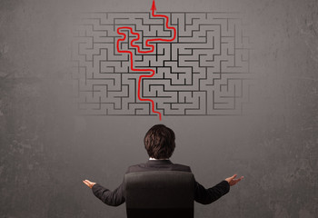 Business man looking at a maze and the way out