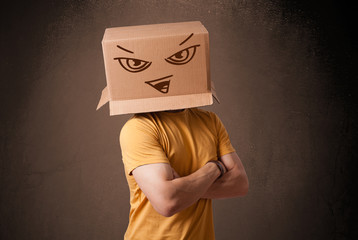 Young man gesturing with a cardboard box on his head with evil f