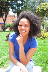 Laughing student with curly hair in a park