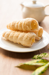 Cream-filled pastry roll on the wood board