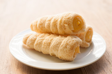 Cream-filled pastry roll on the wood board