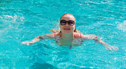 Fototapeta na wymiar Young woman in the swimming pool