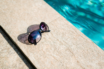 Sunglasses near swimming pool