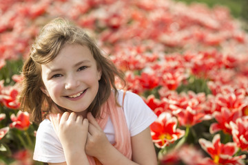 kleines Mädchen in einem Tulpenfeld