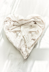 Fototapeta na wymiar Closeup photo of bed sheet in shape of heart