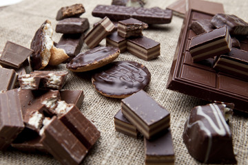 Broken chocolate bar and spices on wooden table