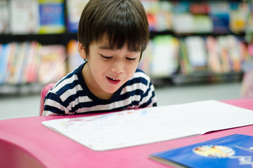 Little Boy in library reading book