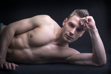 Handsome young man naked on floor.