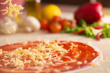 Italian pizza preparation with cheese falling.