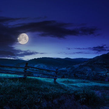 wooden fence in the grass on the hillside at night