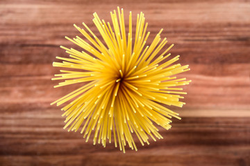 Uncooked pasta spaghetti macaroni on wooden background