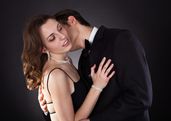 Young Couple Embracing Over Black Background