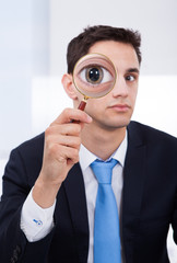 Fototapeta na wymiar Businessman Looking Through Magnifying Glass