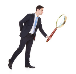 Businessman Holding Large Magnifying Glass