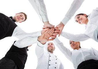 Waiters and waitresses stacking hands