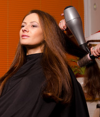 Hairdresser making hair of beautiful girl