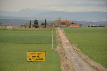 Cartel en carretera de desvio provisional con pueblo al fondo