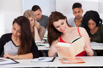 Happy Female Students Studying In Classroom