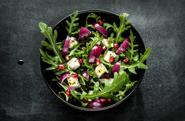 Fresh spring salad with rucola, feta cheese and red onion