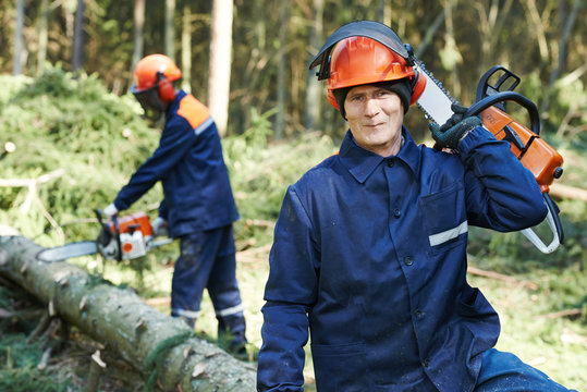 Lumberjack Worker With Chainsaw In The Forest