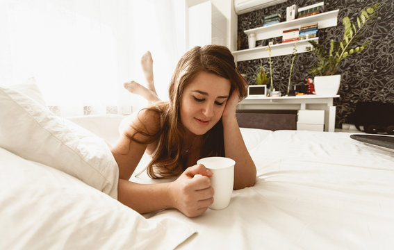 beautiful woman lie in bed with cup of coffee