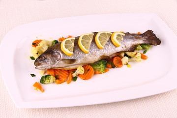 Grilled whole trout with vegetables and lemon