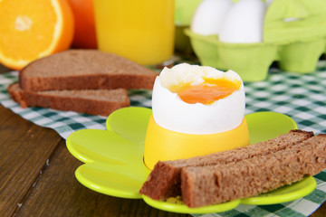 Boiled egg in egg cup on table close-up