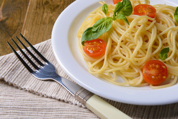 Delicious spaghetti with tomatoes on plate on table close-up