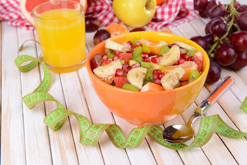 Sweet fresh fruits in bowl on table close-up