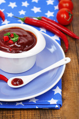 Tomato sauce in bowl on wooden table close-up