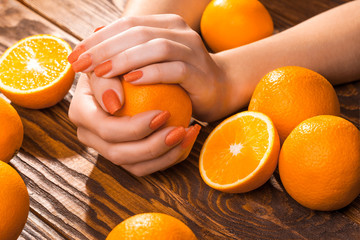 beautiful orange manicure with oranges. on the wood