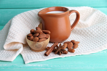 Almond milk in jug with almonds in bowl,