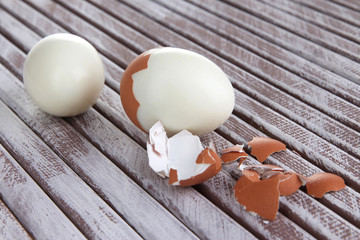 Peeled boiled egg on wooden background