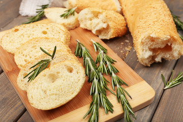 Fresh bread with olive oil and rosemary on wooden table