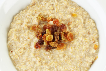 Tasty oatmeal with raisins close up