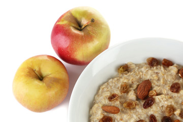 Tasty oatmeal with raisins and apples isolated on white