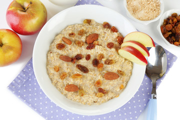 Tasty oatmeal with raisins and apples close up