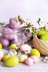 Composition with Easter eggs in glass jar and wicker basket,