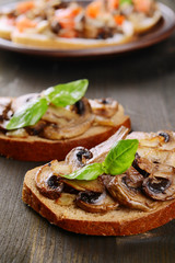 Delicious bruschetta with mushrooms on table close-up