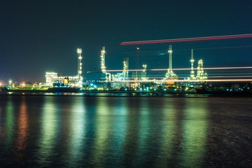 Fototapeta na wymiar Oil refinery at night with light from boat