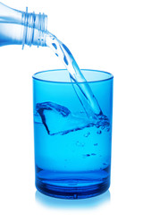 Bottle pouring water into glass on white background.