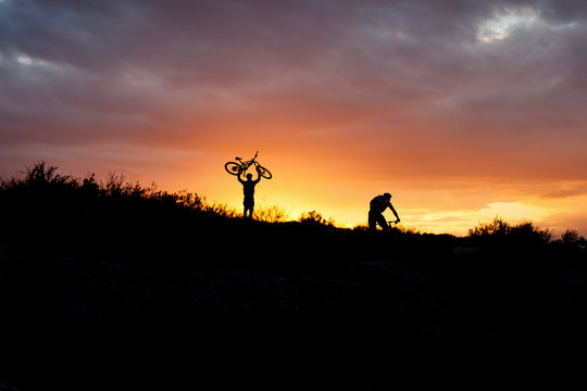 two mountain bikers at the sunset