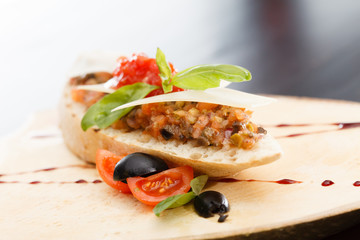 Italian appetizer bruschetta with tomato, basil and black olives