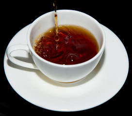 tea in a cup on a black background